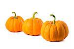 Row of three small pumpkins, isolated on white background