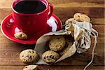 cup of coffee and oatmeal cookies with chocolate on the wooden table. background.