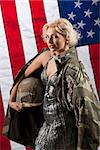 Young beautiful woman in a military jacket holding helmet and american flag