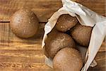 Rye bread in paper bag on wooden background. Close up. Horizontal