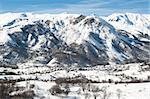 Panoramic view of a snow covered valley with mountain village