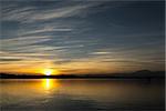 Sunset on the Varese lake in autumn season with blue sky and clouds in background