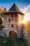 Ancient stone castle Kamianets Podilskyi standing near rural road under blue sky with bright sun