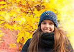 Portrait of smiling young girl in cold weather dressed warm hat in autumn