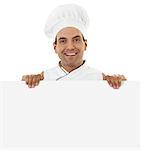 Stock image of a cheerful male chef holding a blank sign isolated on white