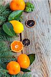 Citrus and spruce branches on the old wooden background.