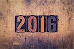 The word "2016" written in dirty vintage letterpress type on a aged wooden background.