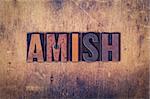 The word "Amish" written in dirty vintage letterpress type on a aged wooden background.