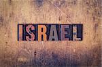 The word "Israel" written in dirty vintage letterpress type on a aged wooden background.