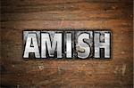 The word "Amish" written in vintage metal letterpress type on an aged wooden background.