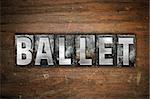 The word "Ballet" written in vintage metal letterpress type on an aged wooden background.