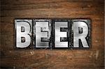 The word "Beer" written in vintage metal letterpress type on an aged wooden background.