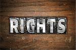 The word "Rights" written in vintage metal letterpress type on an aged wooden background.