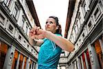 Now it is time to invest in your body and no matter you are at hometown or traveling. Fitness young woman stretching before starting outdoors training next to Uffizi gallery in Florence Italy