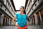 Now it is time to invest in your body and no matter you are at hometown or traveling. Fitness young sporty woman in sportswear and mp3 player staying in front of Uffizi gallery in Florence Italy