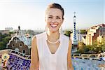 Refreshing promenade in unique Park Guell style in Barcelona, Spain. Portrait of smiling young woman tourist in Park Guell, Barcelona, Spain