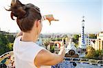 Refreshing promenade in unique Park Guell style in Barcelona, Spain. Seen from behind young woman tourist framing with hands in Park Guell, Barcelona, Spain