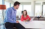 Couple in apartment using laptop