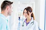 Male and female doctor talking in hospital corridor