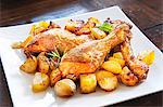 Roast chicken with potatoes, garlic and rosemary