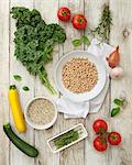 Ingredients for vegan minestrone: kale, quinoa, tomatoes, courgette and chickpeas