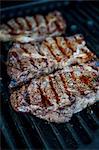 Grilled ribeye steaks on a barbecue