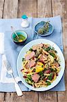 Penne pasta salad with roast beef, courgettes, dried tomatoes and spinach