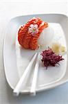 Salmon sashimi on radish strips with a cherry flower