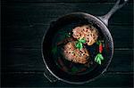 Pepper steaks in a black cast-iron pan