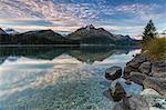 Pink sky at dawn illuminates the peaks reflected in Lake Sils, Engadine, Canton of Graubunden, Switzerland, Europe