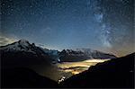 Stars and Milky Way illuminate the snowy peaks around Lac de Cheserys, Chamonix, Haute Savoie, French Alps, France, Europe
