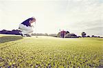 Golfer crouching on course, Korschenbroich, Dusseldorf, Germany