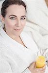 Woman relaxing at home with glass of orange juice