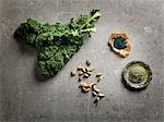 Overhead view of leafy vegetables, cardamom pods and ground supplements