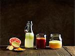 Raw juices in glass bottle and jars, dark background