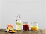 Fruit smoothies in glass bottle and jars, white background