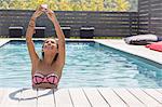 Girl holding up smartphone for selfie in swimming pool, Cassis, Provence, France