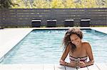 Girl in swimming pool reading smartphone, Cassis, Provence, France