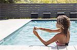 Girl in swimming pool taking smartphone selfie, Cassis, Provence, France