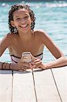 Portrait of girl in swimming pool using smartphone