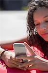 Close up of girl on poolside reading smartphone texts