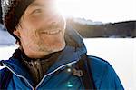 Close up sunlit portrait of mature man hiking in snow covered landscape, Berg, Bavaria, Germany