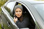 Young woman leaning and looking out from parked  car window