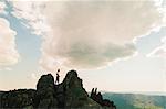 Silhouetted teenage male hiker on top of rugged rock formation, Russia