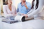 Interior designer discussing swatches with couple in consultation