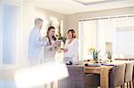 Interior designer using digital tablet in consultation with couple in dining room