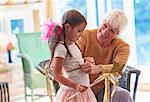Grandmother fitting granddaughter with wings