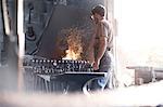 Blacksmith at fire in forge