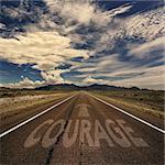 Conceptual image of desert road with the word courage and arrow
