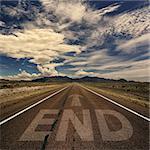 Conceptual image of desert road with the word end and arrow